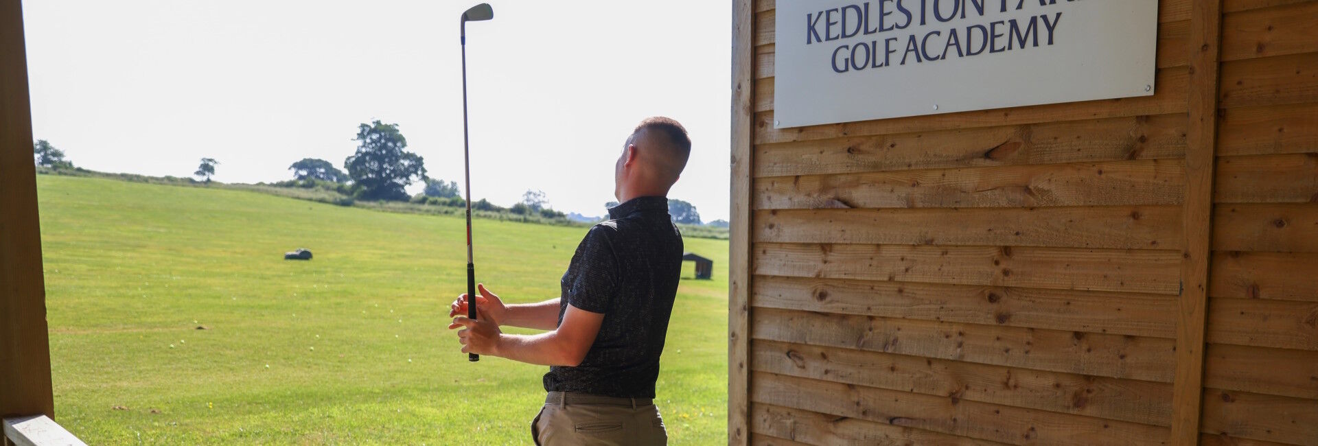 Golfer taking a shot at the driving range at Kedleston Park Golf Club